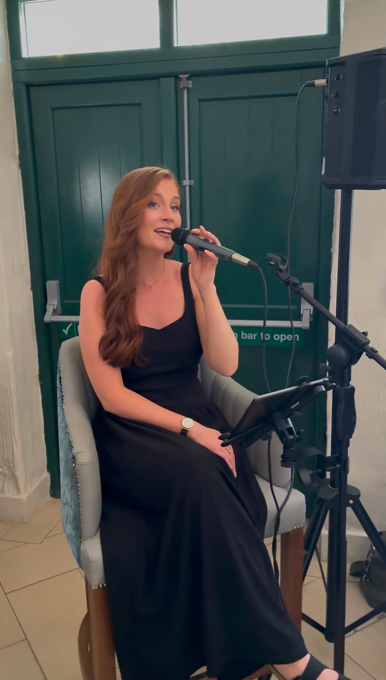 Saoirse Murray singing indoors with a handheld microphone